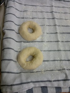 A megformázott bagel karikákat lisztes konyharuhára fektettük és nedves konyharuhával lettek letakarva