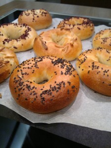 Kisültek a gyönyörű bagel karikák. A vízből kikapott - még nedves - karikákra szezámmag, mandula és lenmag került.